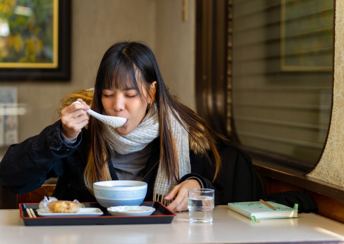 Frau beim Abendessen in einem japanischen Restaurant im Winter