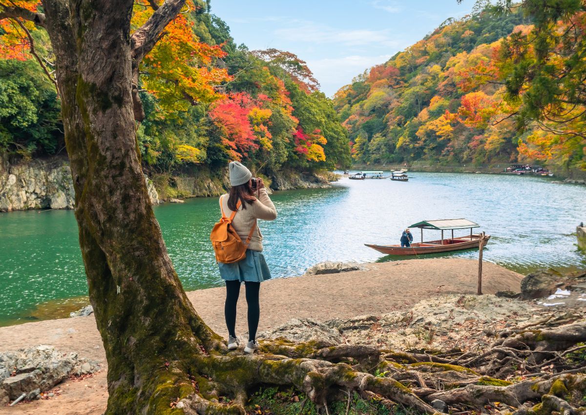 Reisende mit Blick auf Arashiyama im Herbst, Kyoto, Japan