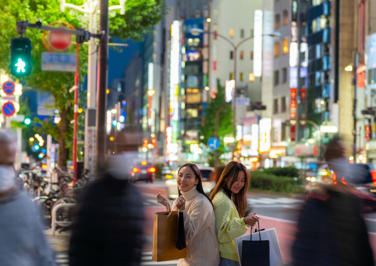 Mädchen gehen nachts in Tokio shoppen