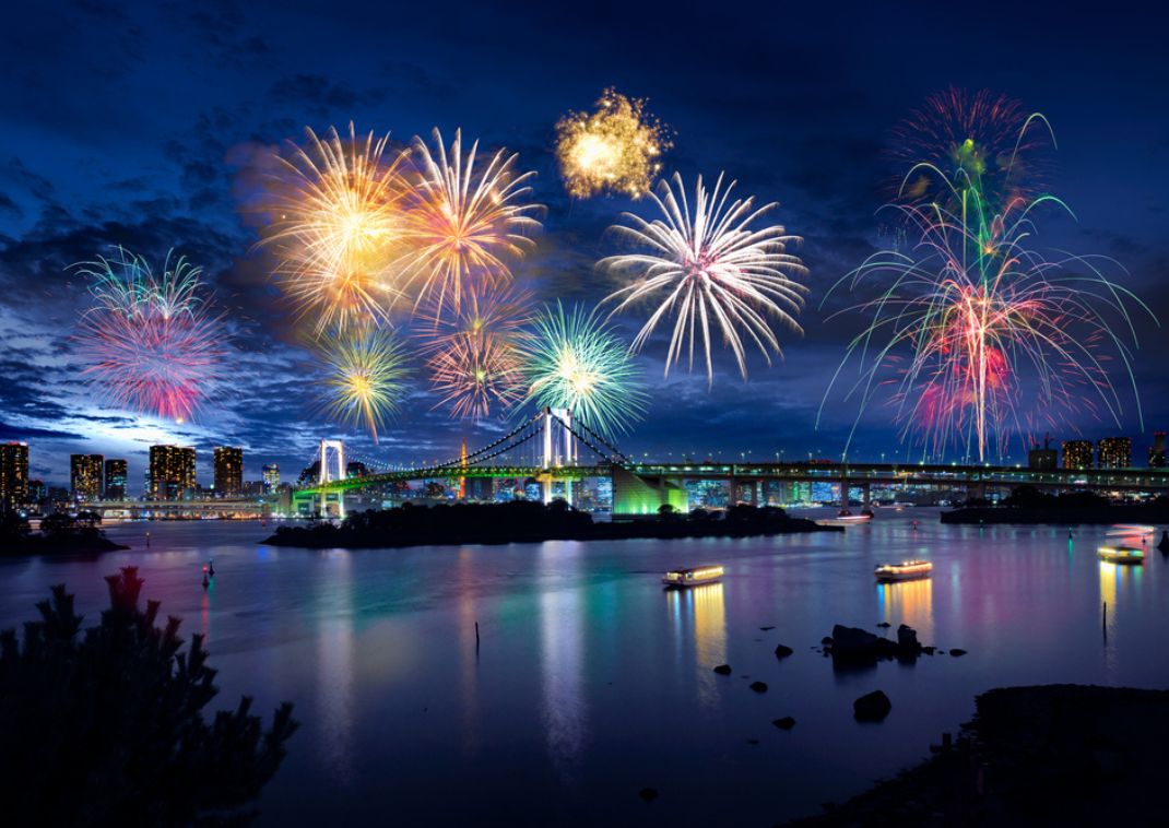 Der Blick auf die Bucht von Tokio und die Regenbogenbrücke von Tokio mit einem wunderschönen Feuerwerk.