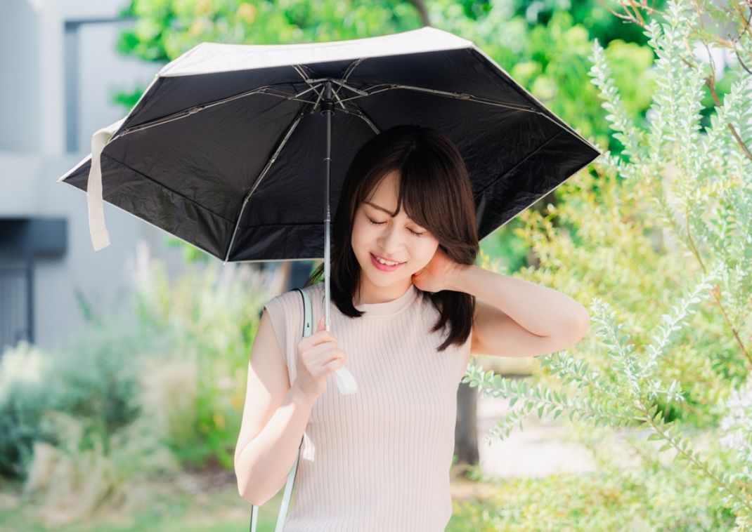 Asiatische Frau mit Sonnenschirm.