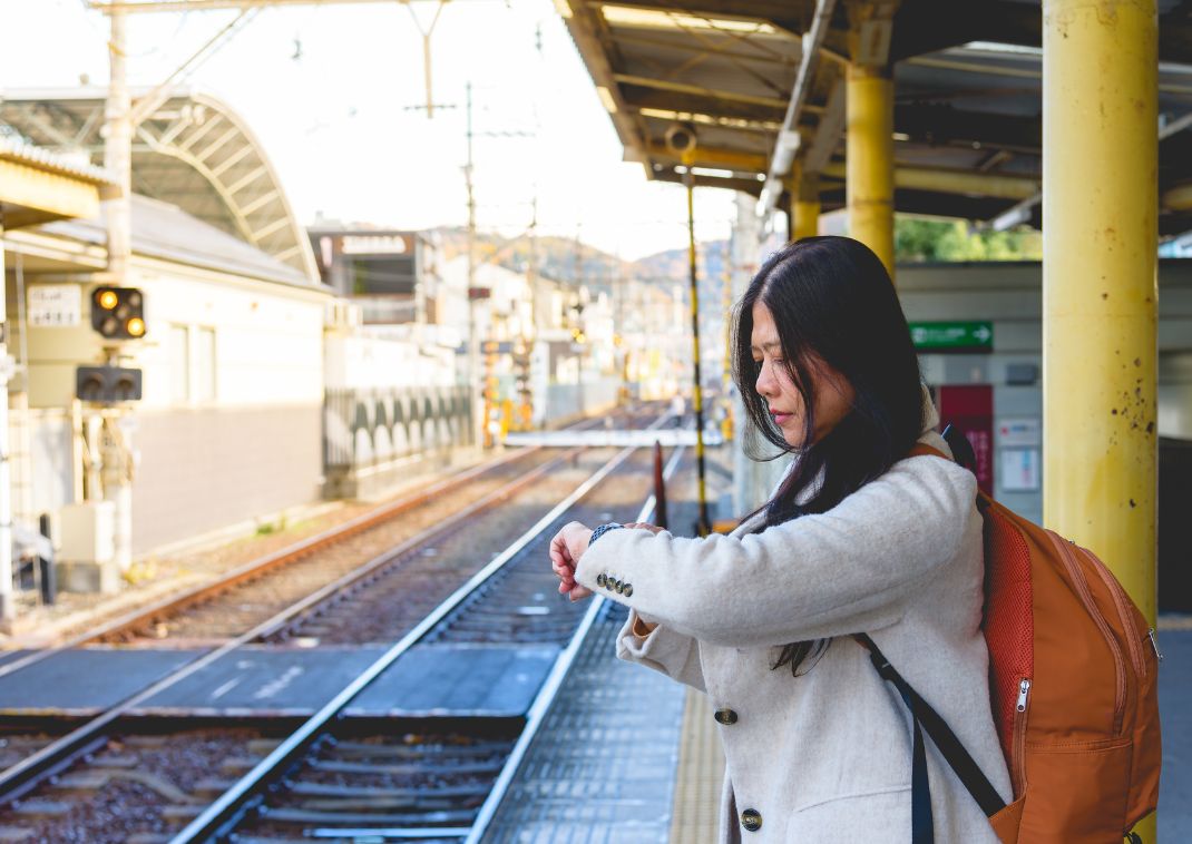 Eine Frau schaut in einem Bahnhof in Japan auf ihre Uhr