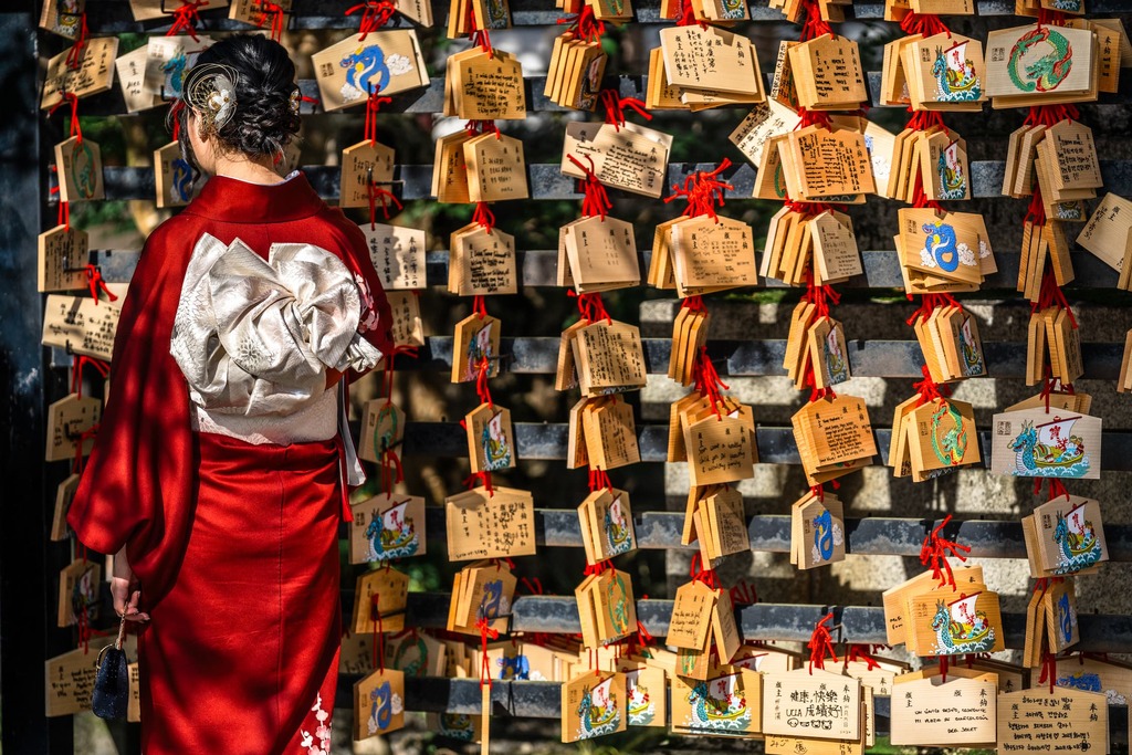 Japanische Frau liest Gebetskarten auf einer Holztafel im Kiyomizu-dera-Tempel in Kyoto