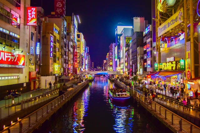 Neonlichter und Streetfood prägen die lebhafte Atmosphäre von Dotonbori am Abend. 